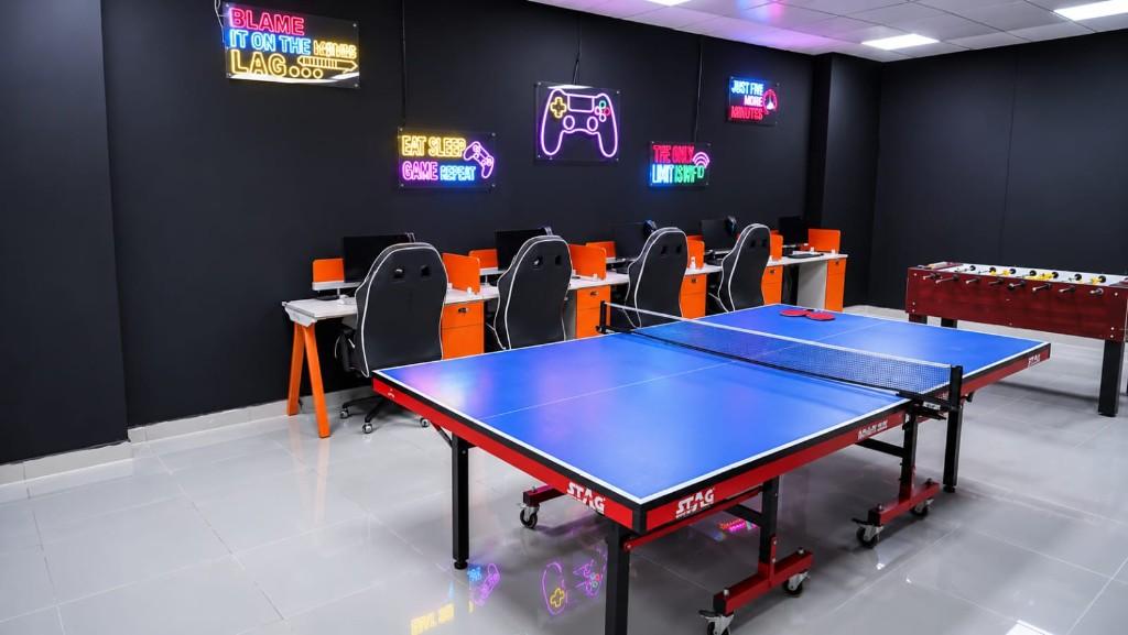 Student recreation room with table tennis, foosball, gaming PCs and neon signage